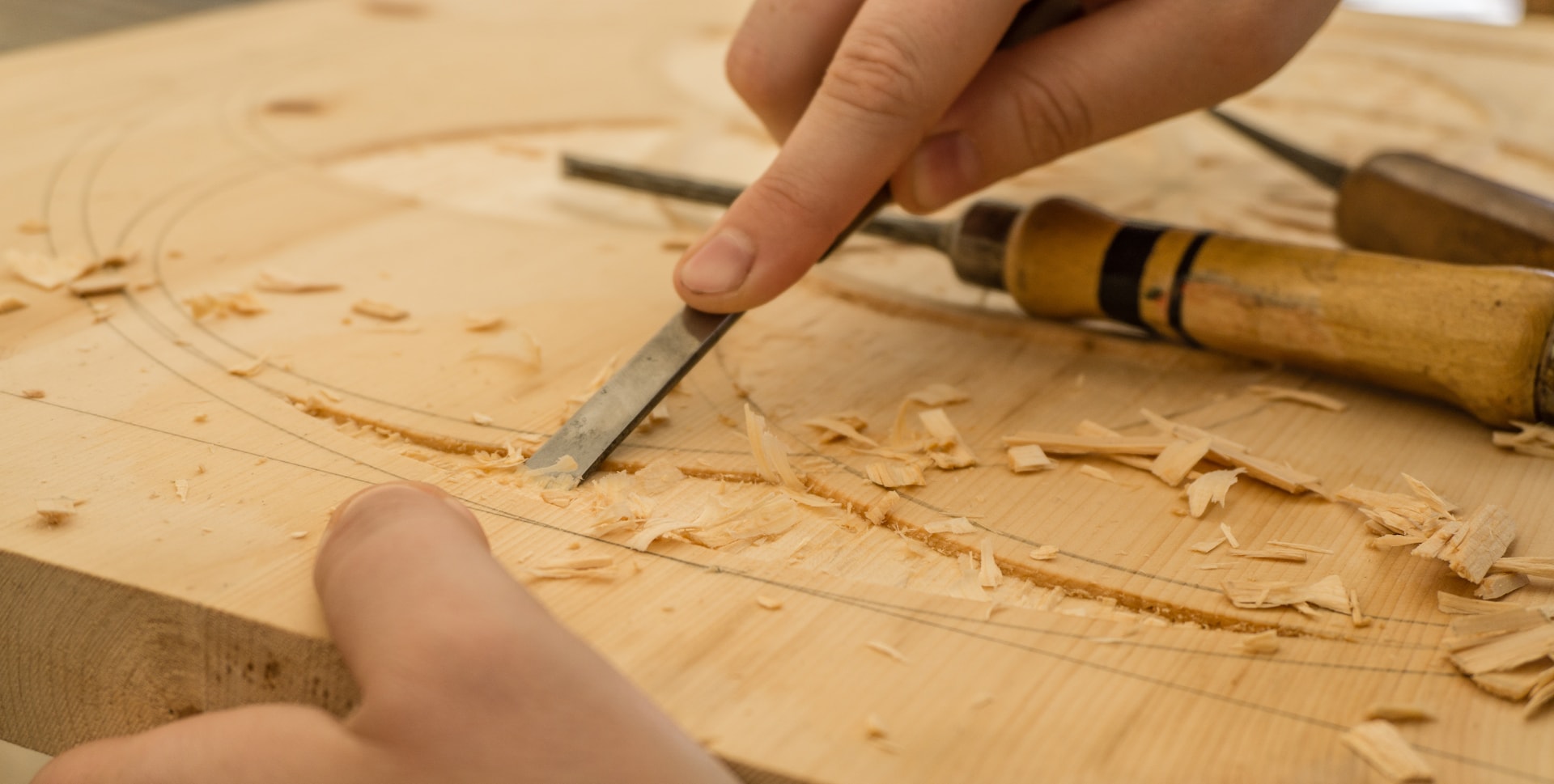 Close-up of a craftsman chiselling a wooden furniture component