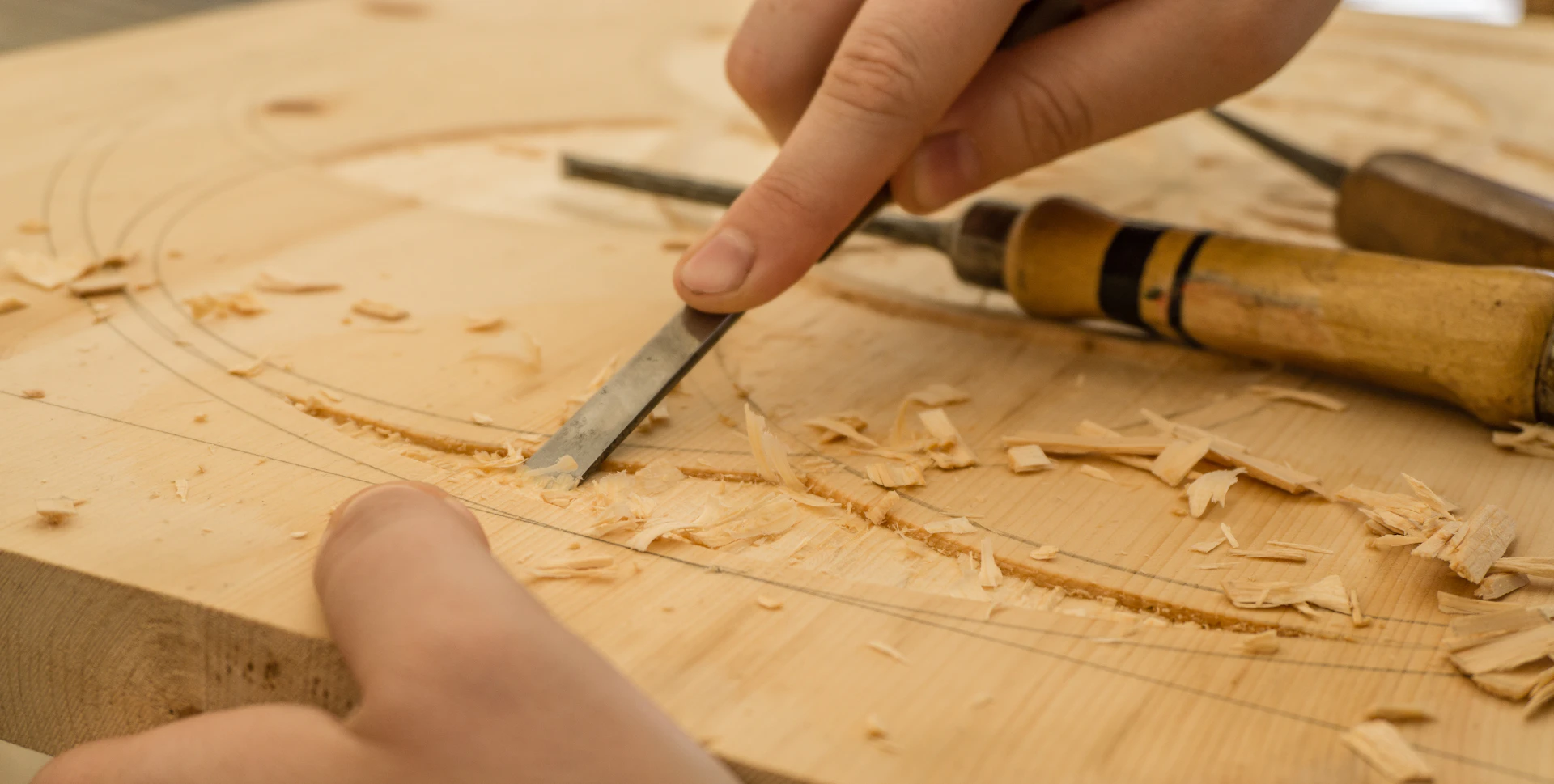 Close-up of a craftsman chiselling a wooden furniture component